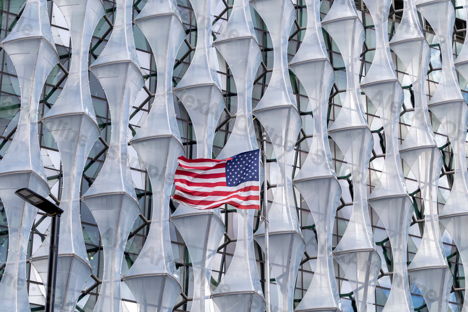 American flag flying against the sculptural glass facade of the US Embassy in London
