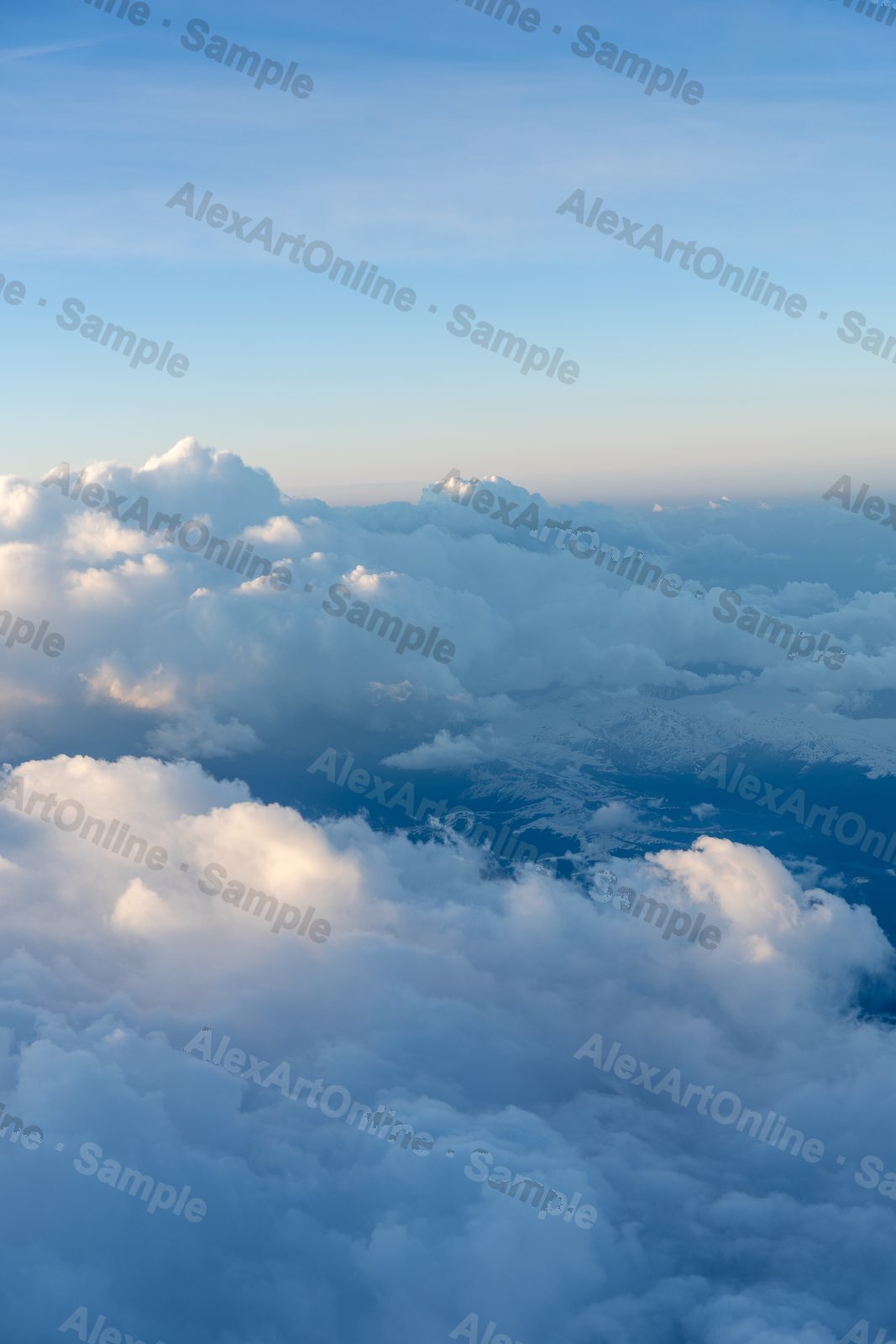 Big white clouds from above under a soft blue sky